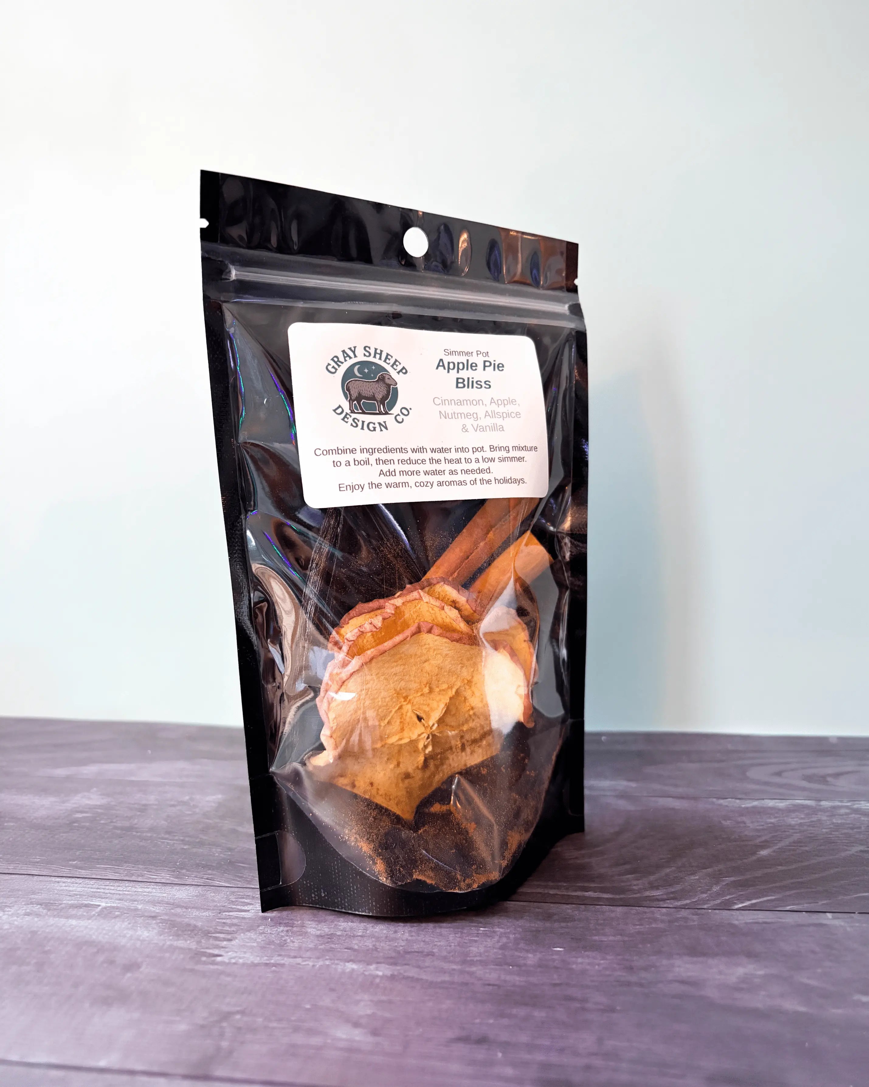 Apple Pie Bliss simmer pot in a resealable black pouch, dried apple slices and cinnamon visible through the window.
