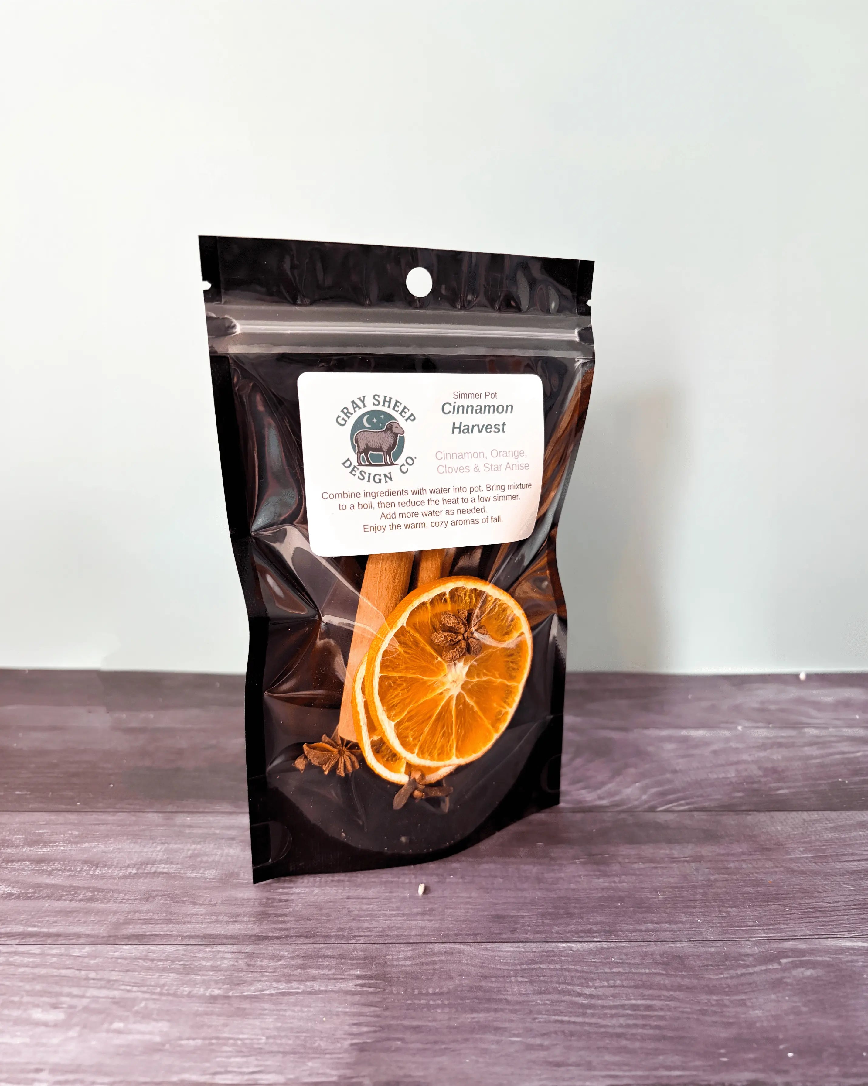 Cinnamon Harvest simmer pot in a resealable black pouch, dried orange, cinnamon, and star anise visible through the window.