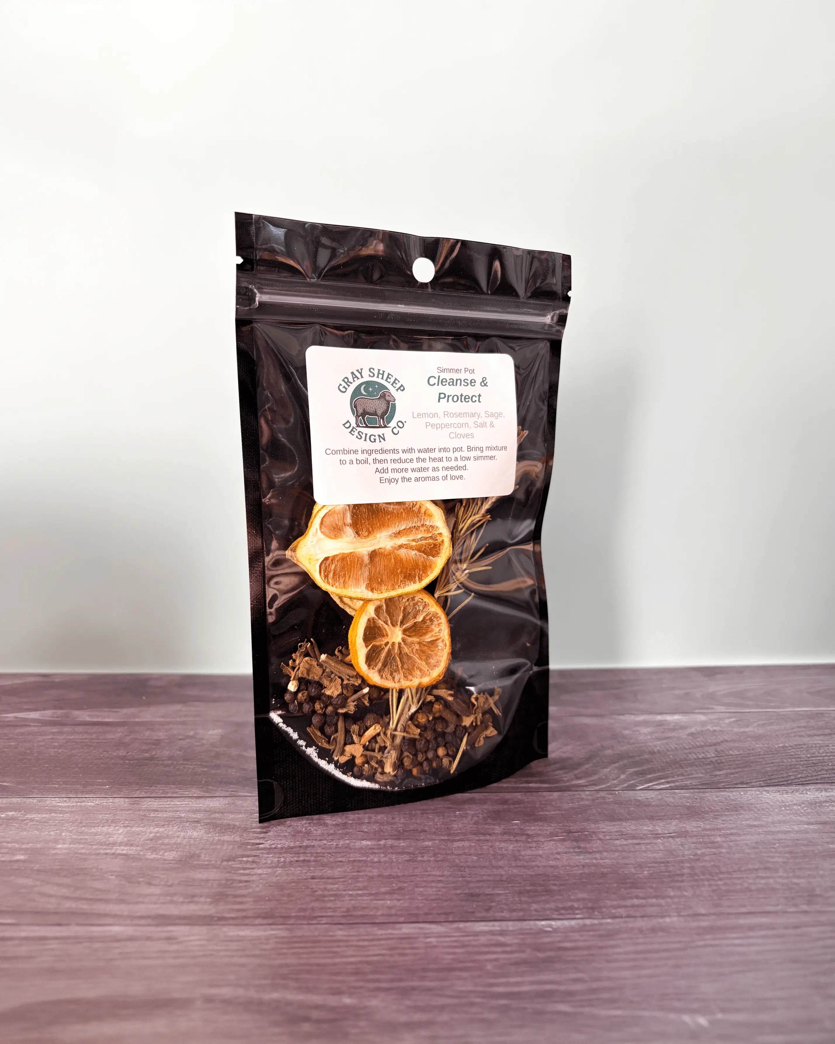 Cleanse & Protect simmer pot in a resealable black pouch, dried lemon slices and herbs visible through the window.