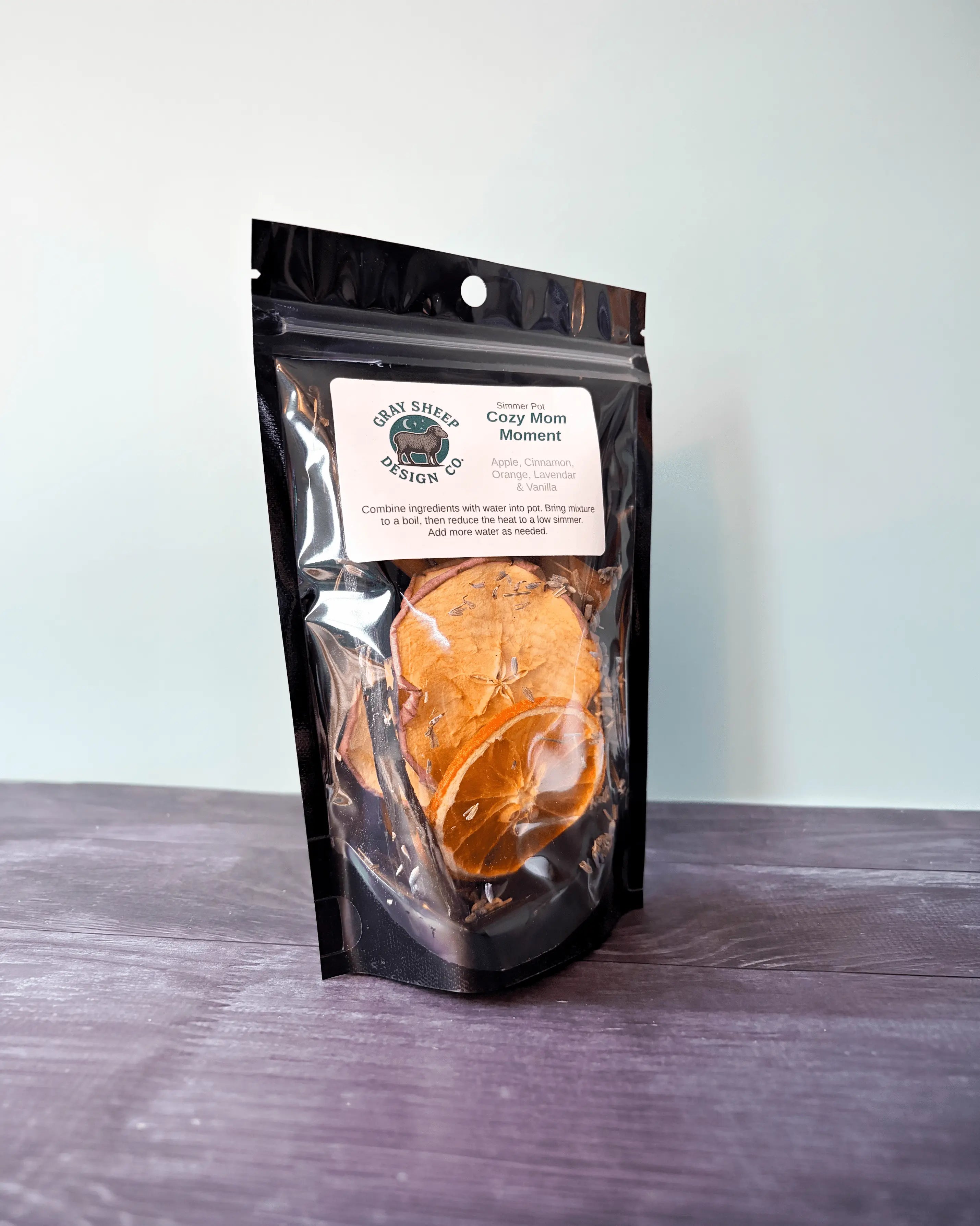 Cozy Mom Moment simmer pot in a resealable black pouch, a dried orange slice visible through the window.