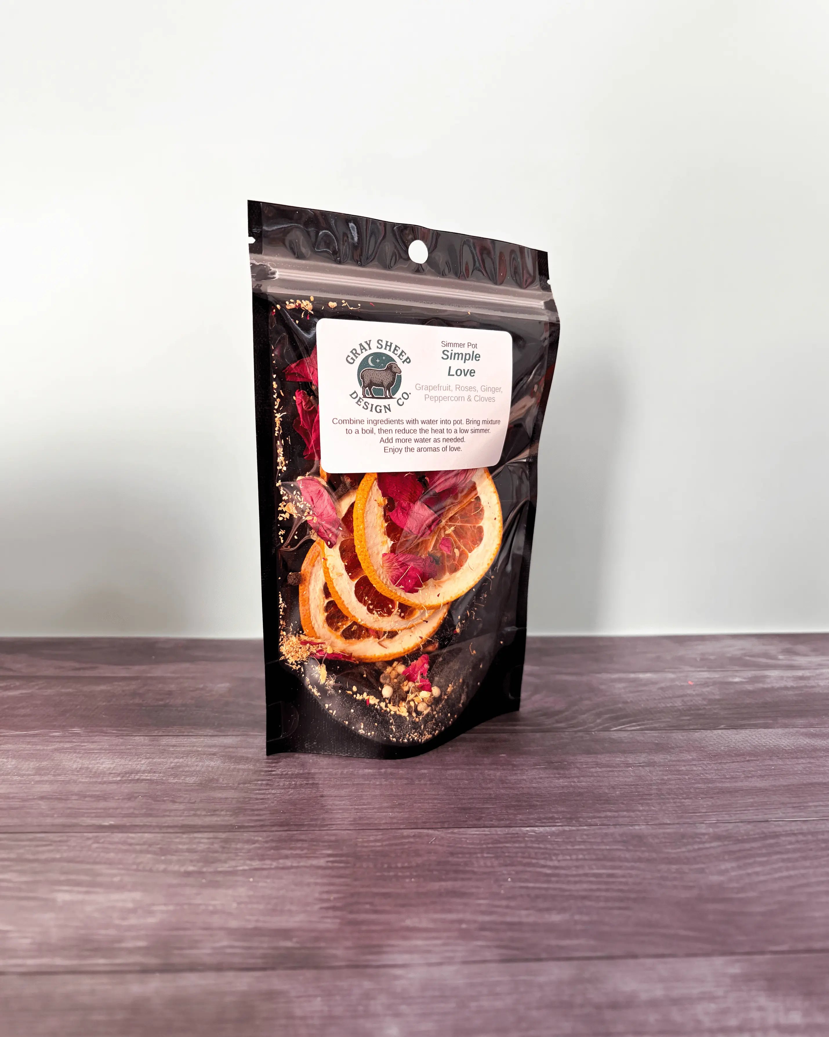 Simple Love simmer pot in a resealable black pouch, dried grapefruit and rose petals visible through the window.